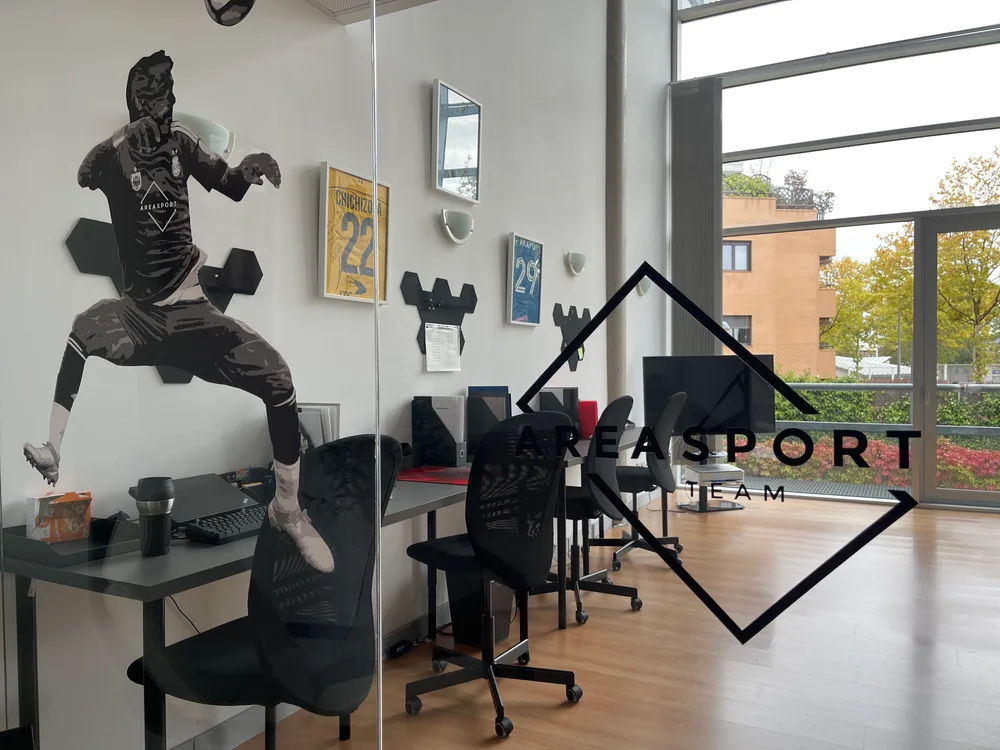 Oficinas de Area Sport Team, con el logo de la agencia y camisetas enmarcadas